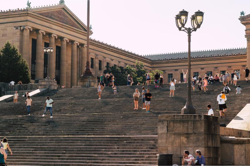 tourists pose on the steps outside the Philadelphia Museum of Art