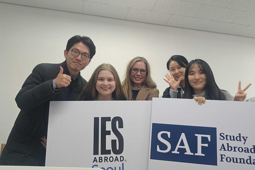 SAF and IES Abroad Seoul Center staff posing with signs of logos