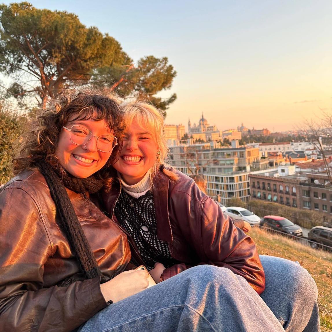 Two students sit high above the city.