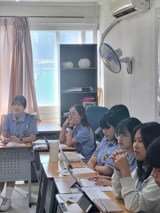 A group of high school students in a marketing and management class listen to a presentation by SAF Korea Director Suyeon Lee. 