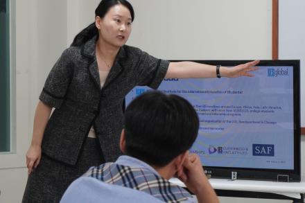 SAF Korea Director Suyeon Lee presents a powerpoint on global mobility to high school students in a marketing and management class.