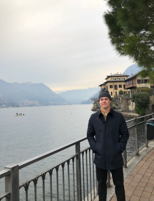A student stands in front of Lake Maggiore