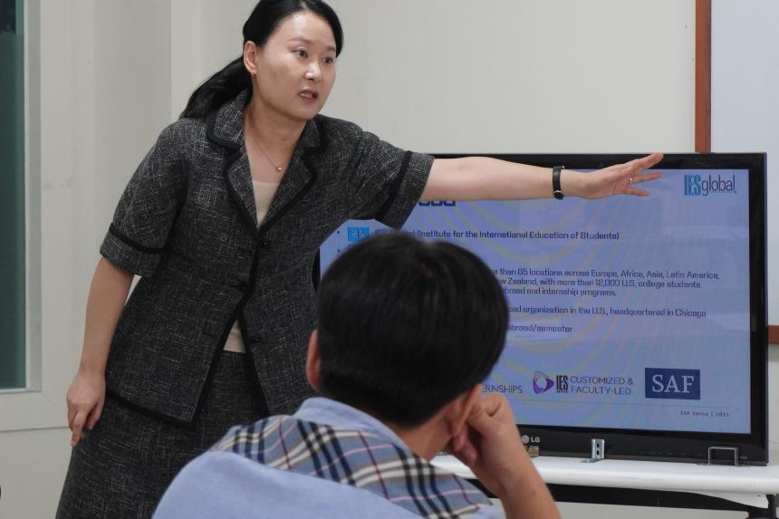 SAF Korea Director Suyeon Lee presents a powerpoint on global mobility to high school students in a marketing and management class.